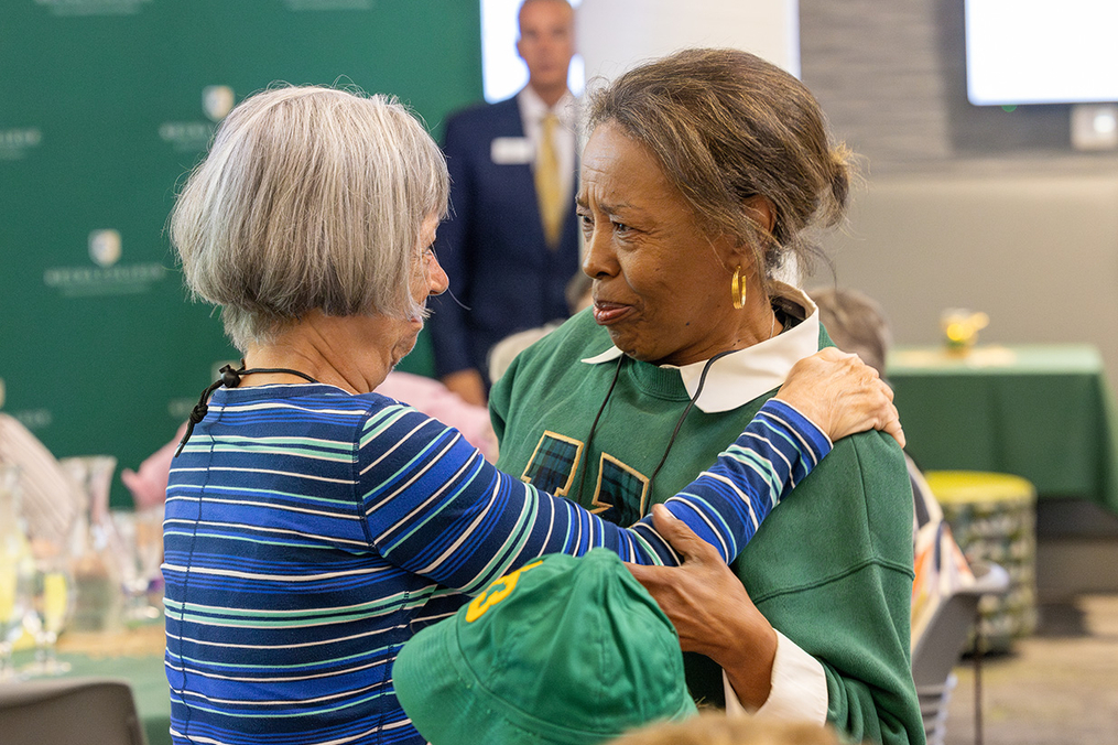 Two old friends embrace at the Pathfinders Luncheon during Green &amp; Gold Alumni and Family Weekend